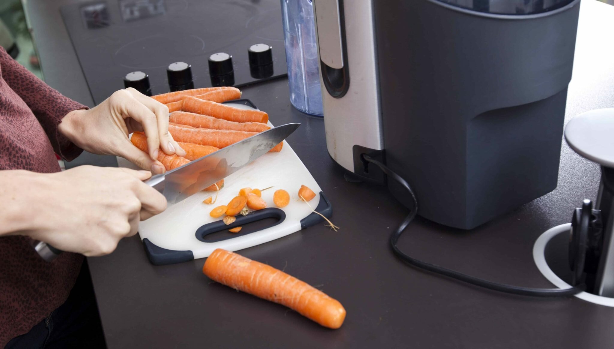 woman cutting carrots into pieces before blending