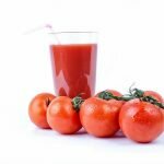 glass tomato juice and tomatoes next to it